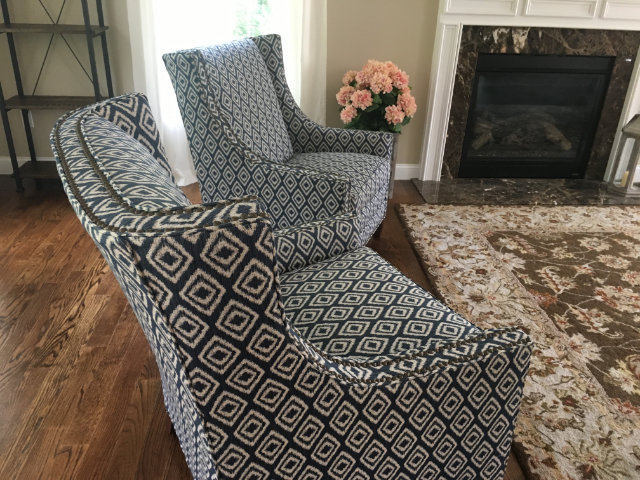 Patterned upholstered chairs by a fireplace
